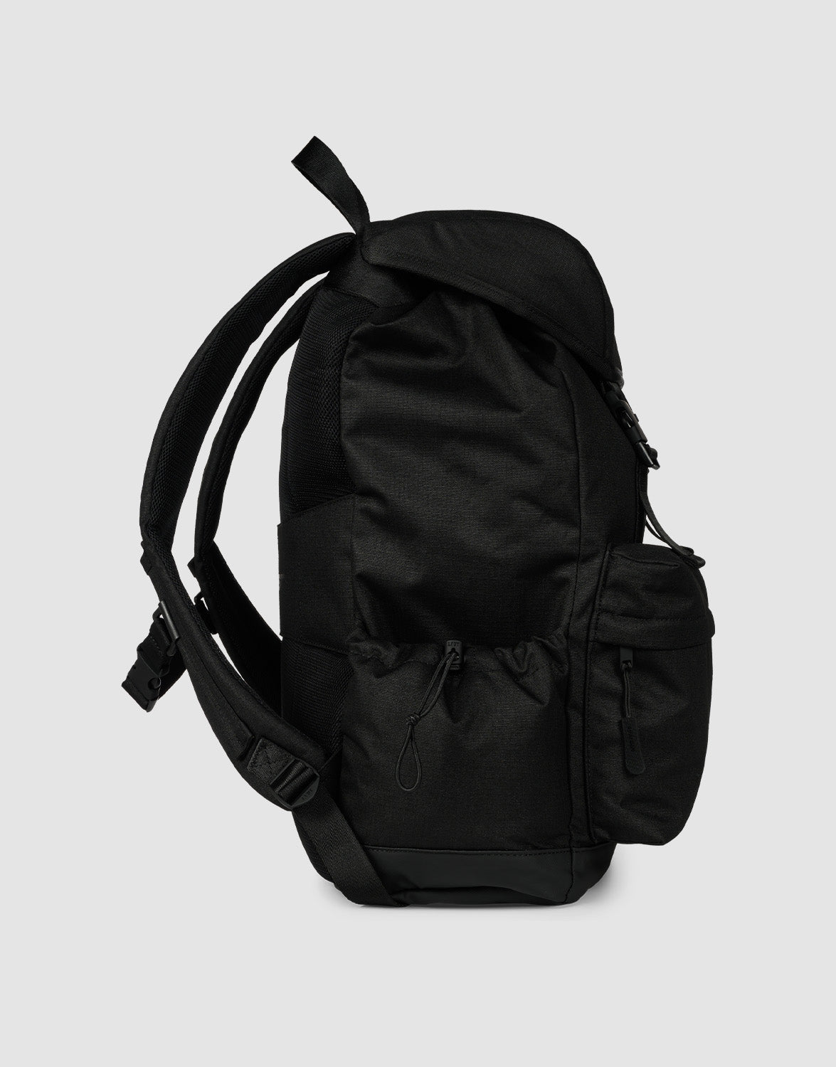 The LFDY Travel Backpack by LIVE FAST DIE YOUNG is a black 25L laptop rucksack with multiple zippered pockets and adjustable shoulder straps, shown from the side against a light gray background.
