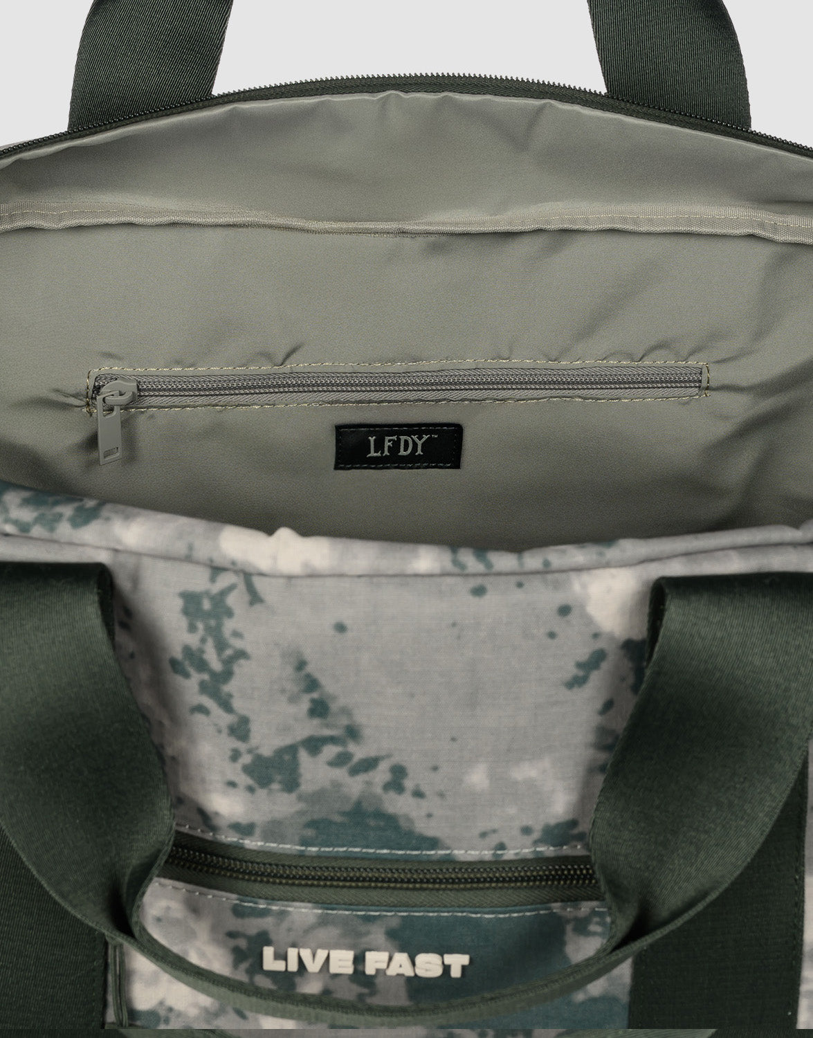 The LFDY Weekender 60 by LIVE FAST DIE YOUNG is an open green duffle bag with a zippered inner pocket, black LFDY label, visible LIVE FAST text on the outer pocket, gray and green splatter interior, and adjustable shoulder strap.