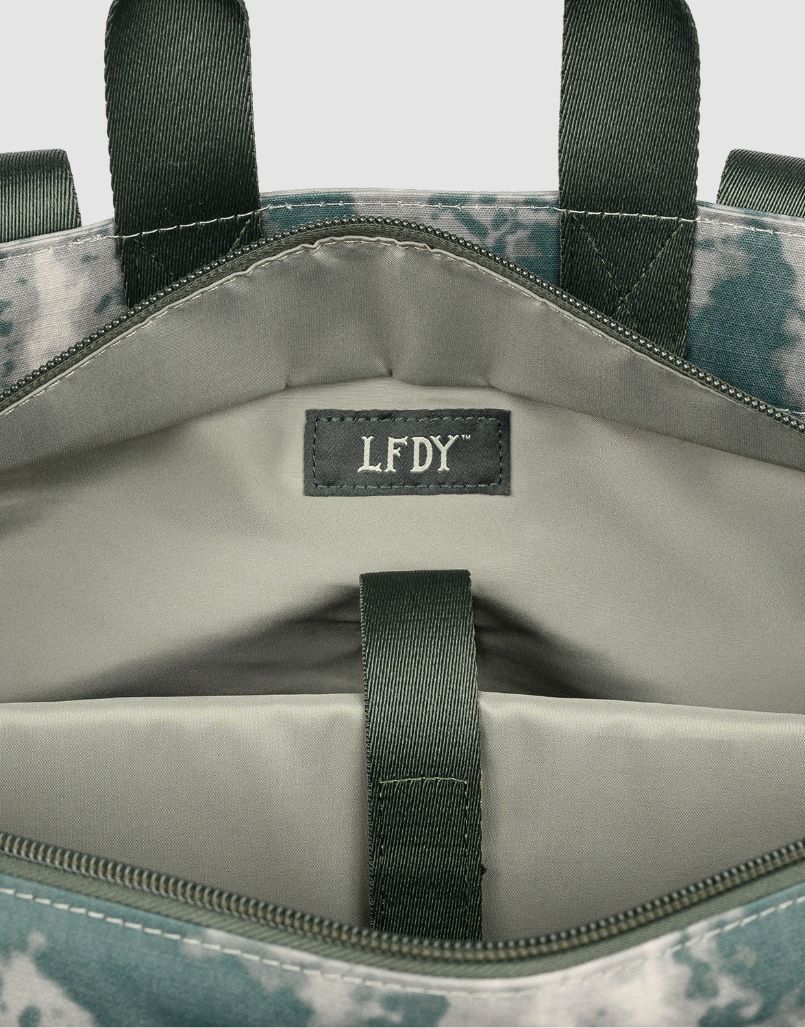 Close-up of the LFDY Weekender 50 by LIVE FAST DIE YOUNG in green and gray. The 50L bag’s interior has a fabric LFDY label, pocket, removable shoulder strap, and green strap detail against a light gray lining.