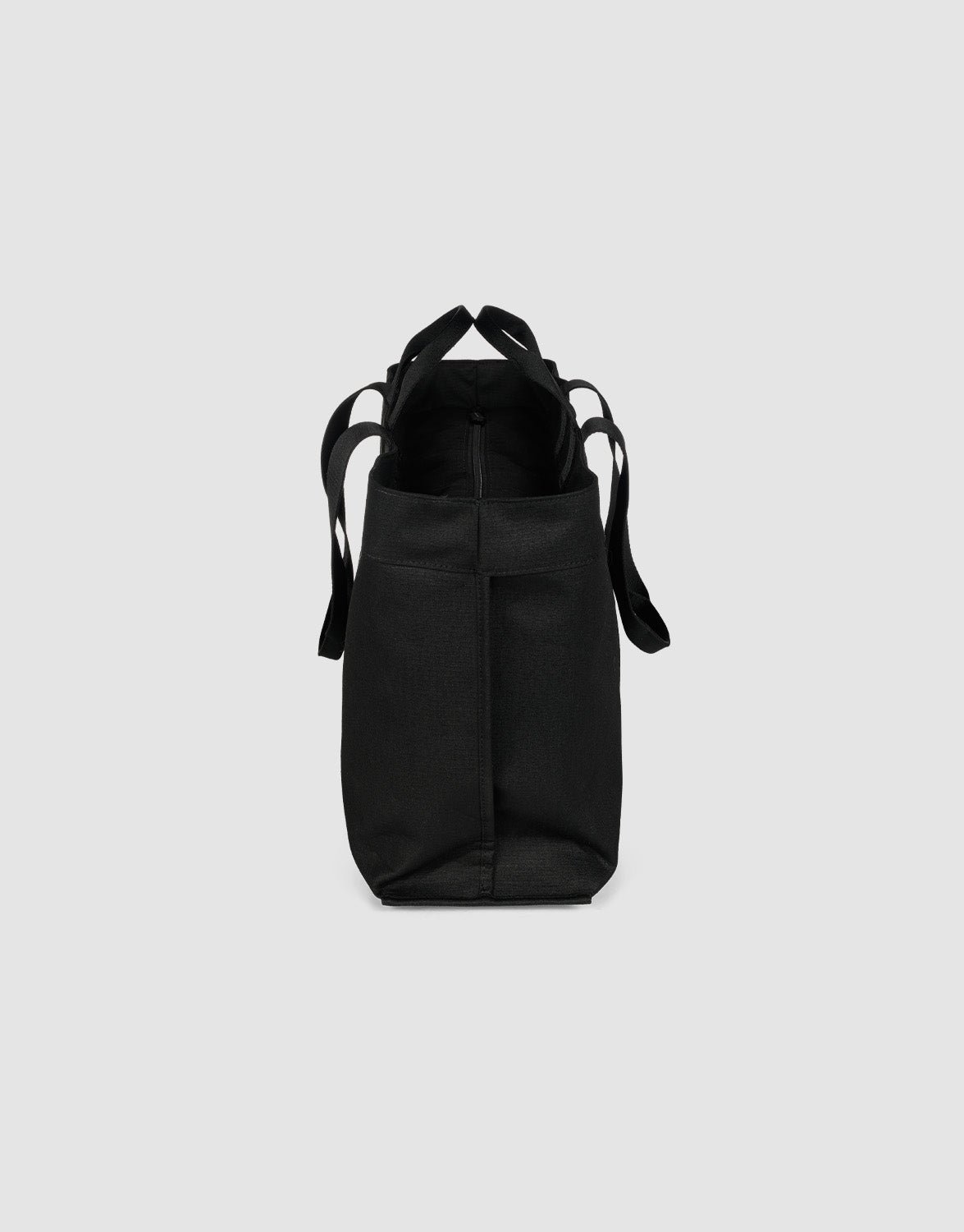 Die LFDY Utility Bag von LIVE FAST DIE YOUNG ist eine schwarze Polyester-Tasche, seitlich vor grauem Hintergrund gezeigt, mit sichtbaren Henkeln und großzügigem Fach für vielseitige Nutzung.