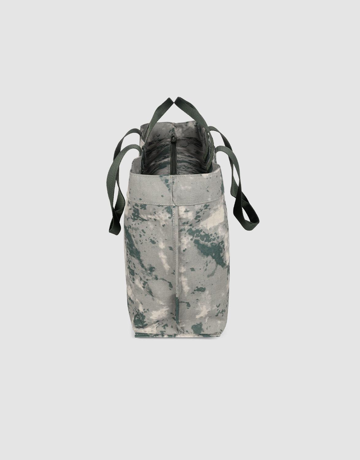 A side view of the LFDY Utility Bag by LIVE FAST DIE YOUNG, featuring a green and gray camo pattern, green straps, top zipper closure, and spacious compartment—ideal as a stylish laptop bag—set against a plain light gray background.