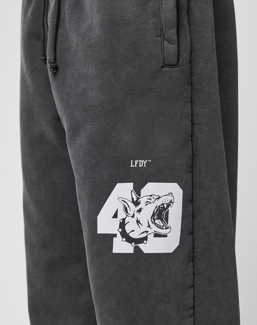 The LFDY 40 Wide Cuff Jogger by LIVE FAST DIE YOUNG are black oversize-fit sweatpants in soft cotton with side pockets, a white 40 and roaring wolf graphic, barbed wire accents, and LFDY text above the number on the left thigh.