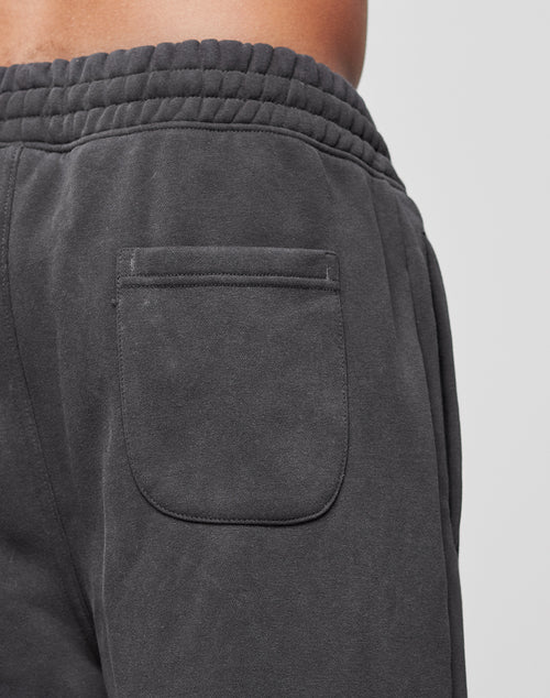Close-up of a person wearing the LFDY Haters Jogger by LIVE FAST DIE YOUNG, featuring a dark gray design with an elastic waistband and a single back patch pocket.