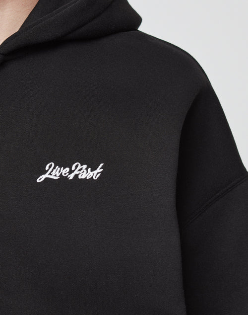 Close-up of the Basic Script Hooded Zip by LIVE FAST DIE YOUNG, a black hoodie made from soft Baumwolle and Polyester, with Live Fast embroidered in white script on the chest.