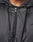 Close-up of a person in the LIVE FAST DIE YOUNG LFDY Winter Bomber Jacket, showing only the lower face, neck, and chest. The shiny black polyester features a hood with metal eyelets and toggles for an Oversize Fit look.