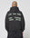 A person with a shaved head and tattoo wears the LIVE FAST DIE YOUNG Live Fast District Hooded Zip in black, featuring bold white spray-paint style text on the back for a signature streetwear look.