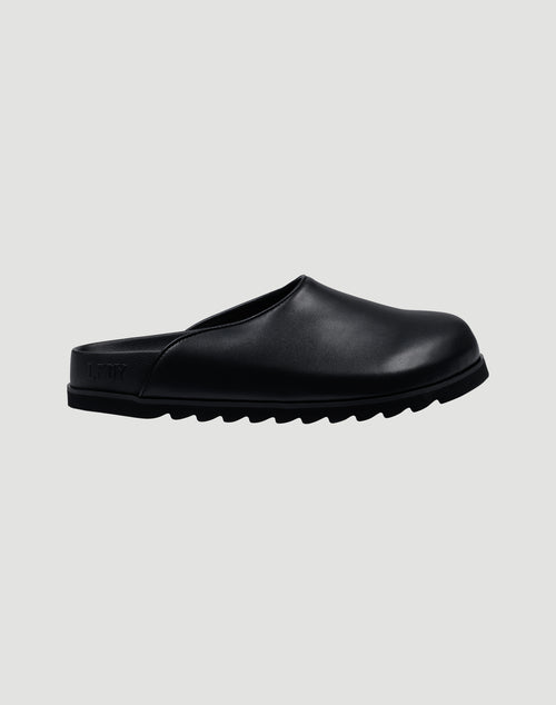 The LFDY Mules by LIVE FAST DIE YOUNG are black slip-on mule shoes with a rounded toe, flat back, thick ridged EVA sole, and schwarze Innenmaterial, shown against a plain light grey background.