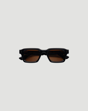 The LFDY x Chimi Shades 03 by LIVE FAST DIE YOUNG are rectangular black acetate sunglasses with thick frames and brown-tinted CR39 lenses offering UV protection. Displayed facing forward on a plain gray background.