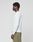 A man with short curly hair stands in profile, wearing the LIVE FAST DIE YOUNG Basic Waffle Longsleeve in oversize fit and olive green pants, set against a plain light grey background.