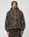 A person with braided hair wears the LIVE FAST DIE YOUNG LFDY Fleece Hooded Zip in a camouflage pattern with kapuze mit kordeln and red embroidered text on the left chest, paired with matching pants against a plain white background.
