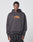 A person stands facing forward wearing a loose-fitting LIVE FAST DIE YOUNG Its Vulgar Center Hooded sweatshirt in an Oversize Fit, with ITS VULGAR printed in orange and yellow on the front against a plain light gray background.