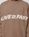 A person wears the Live Fast Boucle Sweater by LIVE FAST DIE YOUNG in brown, featuring "LIVE FAST" in bold white letters across the chest, with the 'A' in FAST uniquely stylized as a star.