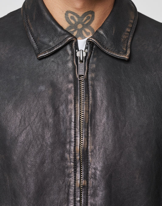 Close-up of a person in a worn black LIVE FAST DIE YOUNG LFDY Leather Jacket, its zipper partially closed. A black tattoo is visible on their neck just above the collar.