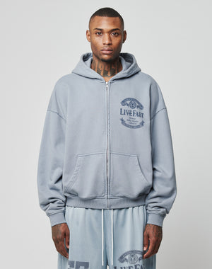 A man with short hair and neck tattoos faces forward, wearing the LIVE FAST DIE YOUNG LFDY 55 Hooded Zip in light gray and matching mesh shorts. He stands against a plain white background with a neutral expression.
