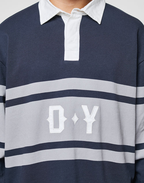 A person wearing the LFDY Striped Polo by LIVE FAST DIE YOUNG, featuring navy blue and gray stripes, a white collar, and D Y embroidered on the front. The image is cropped to display only the upper torso.