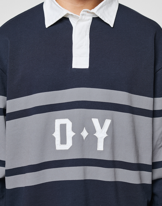 A person wears the LFDY Striped Polo from LIVE FAST DIE YOUNG, featuring navy and gray stripes, a white collar with button placket, and large white "O Y" letters on the front. The person's face is not shown.