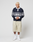 A person with short blond hair wears a LIVE FAST DIE YOUNG LFDY Striped Polo, beige Baumwoll-Twill knee-length shorts, white socks, and white sneakers, standing against a plain white background.