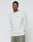 A man in a light gray LIVE FAST DIE YOUNG Basic Longsleeve made from 100% Baumwolle and olive green pants stands against a plain background, calmly facing the camera.