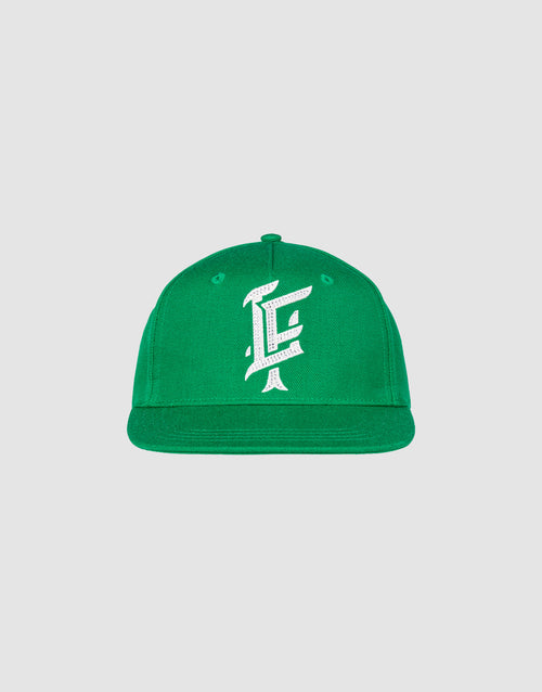 The LF Rhinestone Cap by LIVE FAST DIE YOUNG is a green cotton baseball cap with a flat brim and a white, stylized "E" logo embroidered on the front, displayed against a plain light gray background.