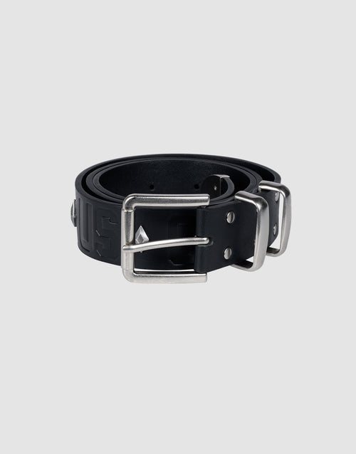 The LFDY Signature Belt by LIVE FAST DIE YOUNG, in black, is rolled up with a rectangular silver buckle and stud accents, displayed on a light gray background.