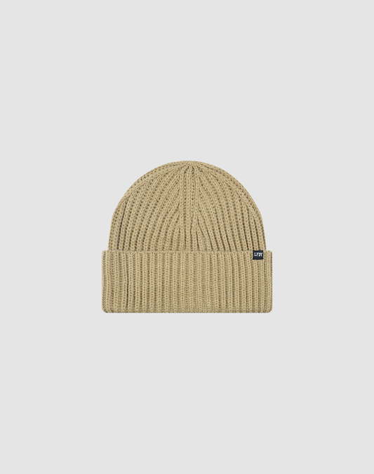 The LIVE FAST DIE YOUNG Washed Rib Knit Beanie in beige features a folded brim, small black flag label on the side, and is crafted from soft polyamide. One Size. Displayed on a plain white background.