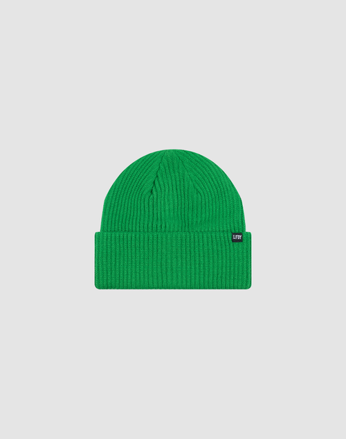 The Double Rib Knit Beanie by LIVE FAST DIE YOUNG is bright green, doppellagig gestrickt for extra volume, with a folded brim and a small black tag with white text on the left. Shown on a plain light grey background.