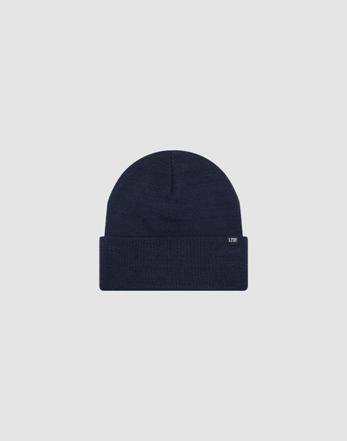 The LIVE FAST DIE YOUNG Basic Beanie in navy blue features a folded brim and a small rectangular flag label on the cuff, shown in one size against a plain light gray background.