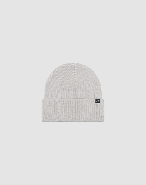 The LIVE FAST DIE YOUNG Basic Beanie is a light gray knit, one size, with a folded cuff and a small black rectangular flag-label, shown against a plain white background.