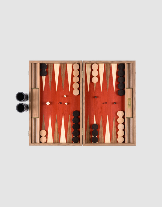 The LFDY Backgammon by LIVE FAST DIE YOUNG features a handcrafted board from Greece, black and white pieces set for play, two dice in the center, dice cups on the left, and a doubling cube on the right against a plain background.