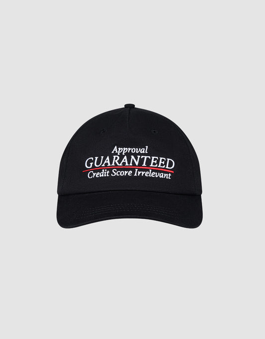 The LIVE FAST DIE YOUNG LFDY Guaranteed Cap is a black unstructured 5-panel, 100% polyester cap with "Approval GUARANTEED Credit Score Irrelevant" embroidered in bold white and red on the front and a snap closure, shown on a light gray background.