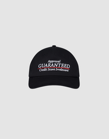 The LFDY Guaranteed Cap by LIVE FAST DIE YOUNG is an unstructured 5-panel black cap made of 100% polyester, featuring "Approval GUARANTEED Credit Score Irrelevant" embroidered in white and red, and an adjustable Snapverschluss. Displayed on a gray background.