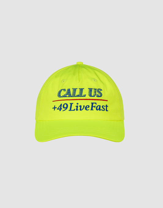 The LFDY Hotline Cap by LIVE FAST DIE YOUNG is a bright yellow, unstructured 5-panel cap with "CALL US" and "+49LiveFast" embroidered in blue on the front.