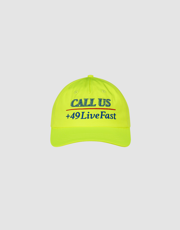 The LFDY Hotline Cap by LIVE FAST DIE YOUNG is a bright yellow 5-panel cap featuring blue CALL US embroidery above a red line and +49LiveFast below, shown on a plain white background.