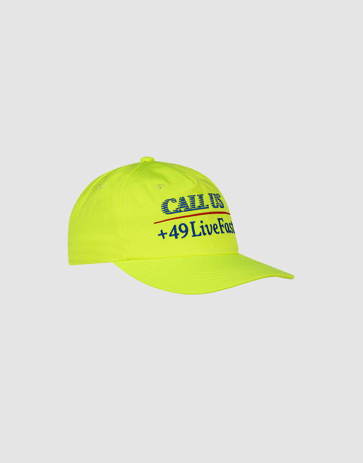 The LFDY Hotline Cap by LIVE FAST DIE YOUNG is a neon yellow 5-panel cap featuring CALL US and +49LiveFast in blue and black on the front. The unstructured cap is shown on a plain light gray background.