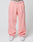 Person wears loose-fitting pink Basic Wide Jogger sweatpants by LIVE FAST DIE YOUNG with an elastic drawstring waist and a white logo waistband, paired with white sneakers. Image is cropped above the waist; plain, light background.