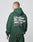 A person wears an oversized dark green LIVE FAST DIE YOUNG Basic 360 Hooded and matching pants, seen from behind. The hoodie shows bold white LiveFast HvySweat 360g/m² text, laundry symbols, front/back print, and is 70% Baumwolle.