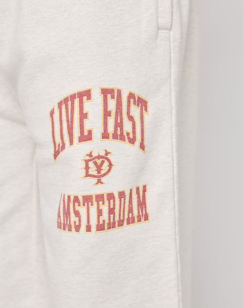 A close-up of the Live Fast Amsterdam Loose Jogger by LIVE FAST DIE YOUNG in light gray, featuring red and yellow LIVE FAST AMSTERDAM text, a small LY emblem, and a comfy elastic waistband in soft cotton.