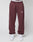 Someone wearing maroon Wide Cuff Jogger sweatpants by LIVE FAST DIE YOUNG, featuring "Live Fast" on the left thigh and branded waistband, paired with white sneakers, stands against a plain light background.