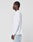 A person with braided hair wears the LIVE FAST DIE YOUNG Blank Waffle Longsleeve in oversize fit and light blue jeans, standing in profile facing left against a plain white background.
