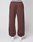 A person wears loose-fitting brown Wide Cuff Jogger by LIVE FAST DIE YOUNG, made from soft French Terry with an elastic waistband and side patch pocket, styled with white sneakers. Photo is taken from behind against a plain light background.