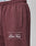 Close-up of maroon Wide Cuff Jogger by LIVE FAST DIE YOUNG, featuring a pocket and PARIS LIVE FAST DIE YOUNG printed in white near the left thigh. Wide fit with waistband showing LIVE FAST text at the top.