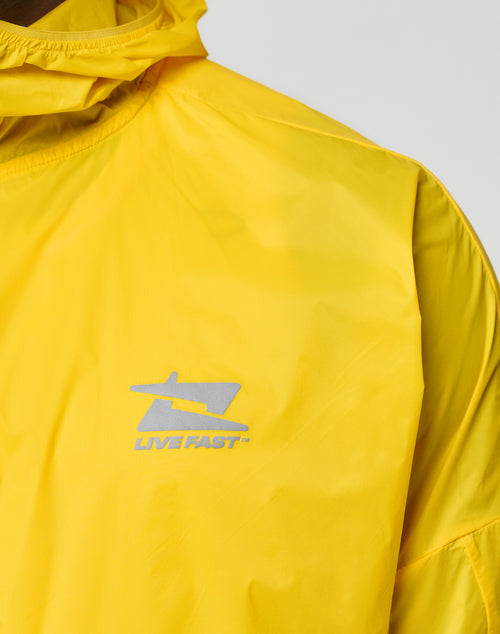 Close-up of the LIVE FAST DIE YOUNG Live Fast Performance Running Jacket in bright yellow, with Kapuze mit Visor, a silver LIVE FAST logo, reflektierender Frontprint, and a shiny, lightweight material in regular fit.