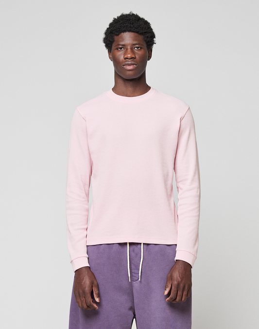 A man stands facing forward, wearing a LIVE FAST DIE YOUNG Basic Waffle Longsleeve in light pink and loose-fitting purple Oversize Fit pants with a white drawstring, set against a plain light gray background.