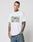 A tattooed man wears the LFDY Sixers Tee by LIVE FAST DIE YOUNG—a white, regular fit 100% cotton t-shirt with a colorful graphic print—and blue jeans, standing against a light background and facing the camera.