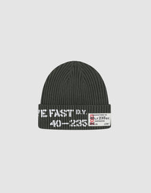 The Live Fast Army Beanie by LIVE FAST DIE YOUNG is a dark gray ribbed knit hat made from 100% Baumwolle, featuring white text and a small frayed web label with numbers and symbols on the folded brim, shown on a plain light gray background. 