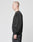 A person with a shaved head stands in profile against a plain light gray background, wearing an oversize fit Basic Blank Sweater and black pants by LIVE FAST DIE YOUNG, both crafted from soft Baumwolle.