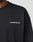 A person wears a black Basic Longsleeve by LIVE FAST DIE YOUNG, featuring a white LiveFastDieYoung™ logo print on the left chest; their face is not visible.