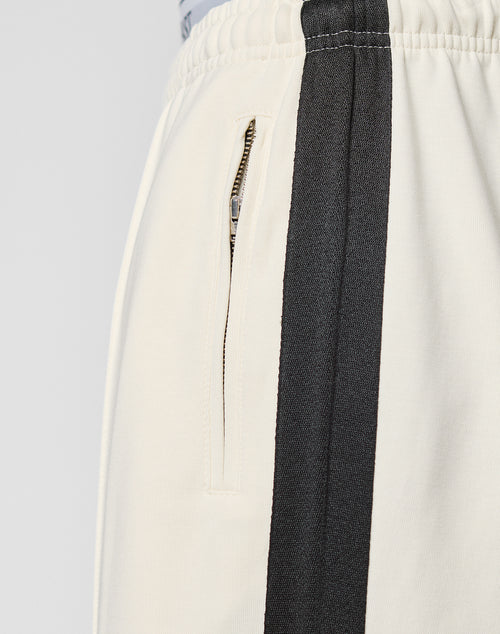 Close-up of the LFDY Striped Jogger by LIVE FAST DIE YOUNG, featuring a wide fit, elastic waistband, vertical side zipper pocket, and a bold dark Fischgräten tape stripe along the leg.