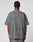 A person with short hair is seen from behind, wearing an oversize fit, faded gray LFDY Hardwear Tee by LIVE FAST DIE YOUNG with subtle front and back prints, paired with gray jeans against a plain white background.