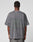 A person wears an oversize fit, faded gray LFDY Hardwear Tee by LIVE FAST DIE YOUNG, featuring a large dark backprint and text, standing with their back to the camera against a plain light background.